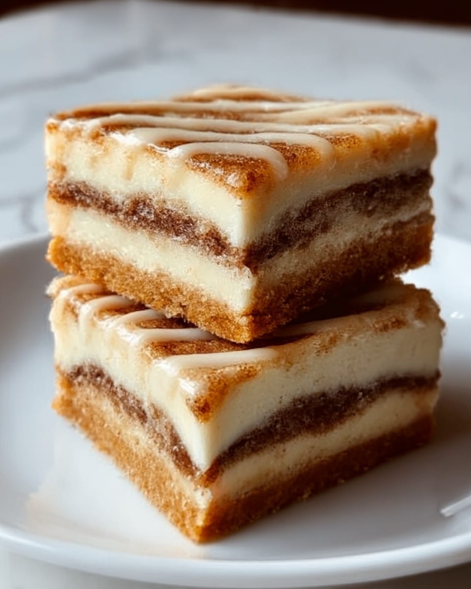 The image shows two square pieces of a layered dessert stacked on a white plate. Each piece has three visible layers: a golden brown crust on the bottom, a thick creamy white middle layer, and a darker brown cinnamon-filled layer in between. The top layer is drizzled with a light brown glaze, creating a soft shiny texture. The layers look soft and moist, with the cinnamon layer showing a slightly swirled pattern. The background is a white marbled texture with soft lighting, emphasizing the dessert’s warm colors and textures. Photo taken with an iphone --ar 4:5 --v 7