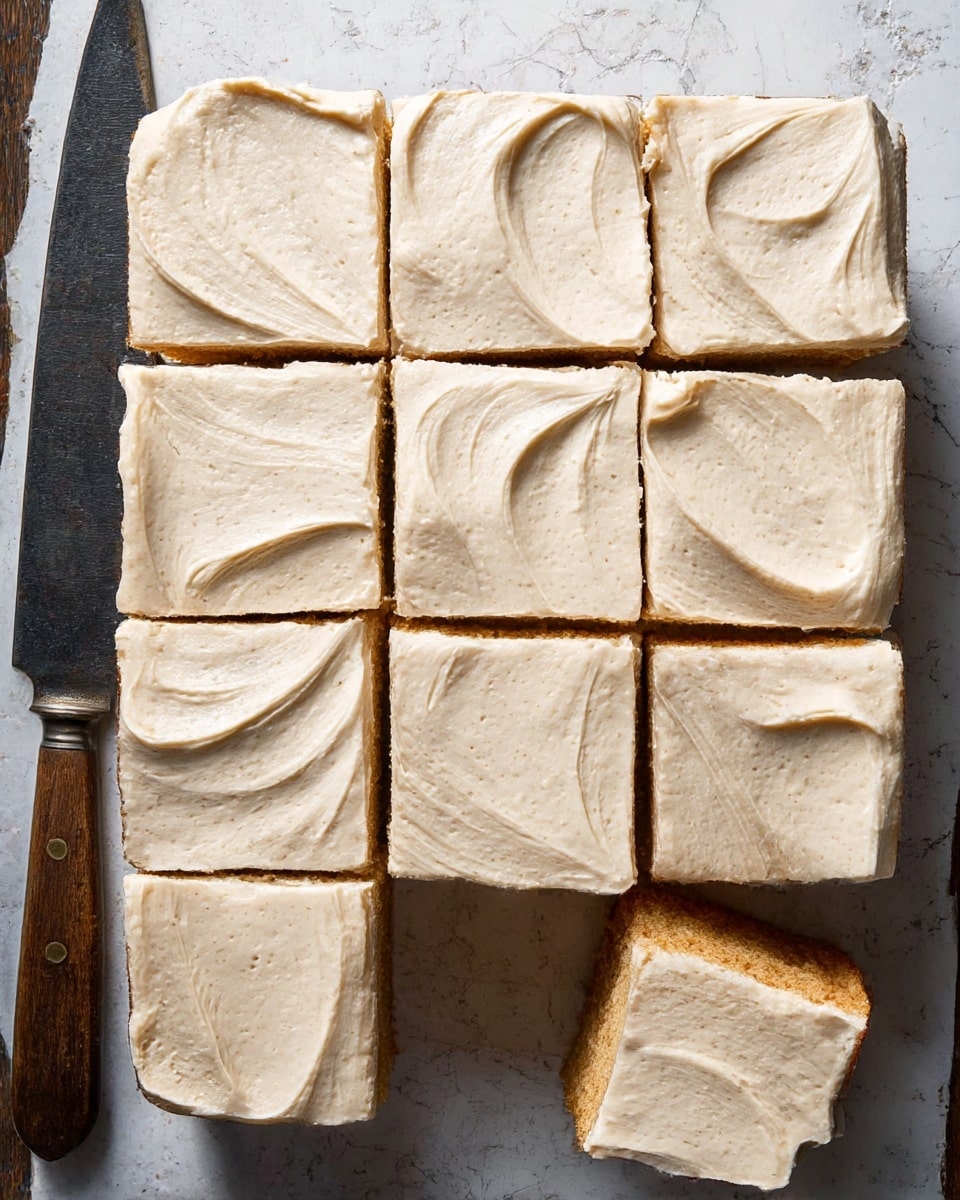 A square cake cut into nine even pieces is shown from above, each piece topped with a thick layer of smooth, light beige frosting that has subtle specks and gentle swirling textures across the surface. The cake base beneath the frosting is a warm, golden brown with a moist, soft appearance. The cuts between the pieces are clean and straight, revealing the contrast between the creamy frosting and the denser cake underneath. The cake is placed directly on a rustic wooden board, which is slightly visible at the edges. Photo taken with an iphone --ar 4:5 --v 7