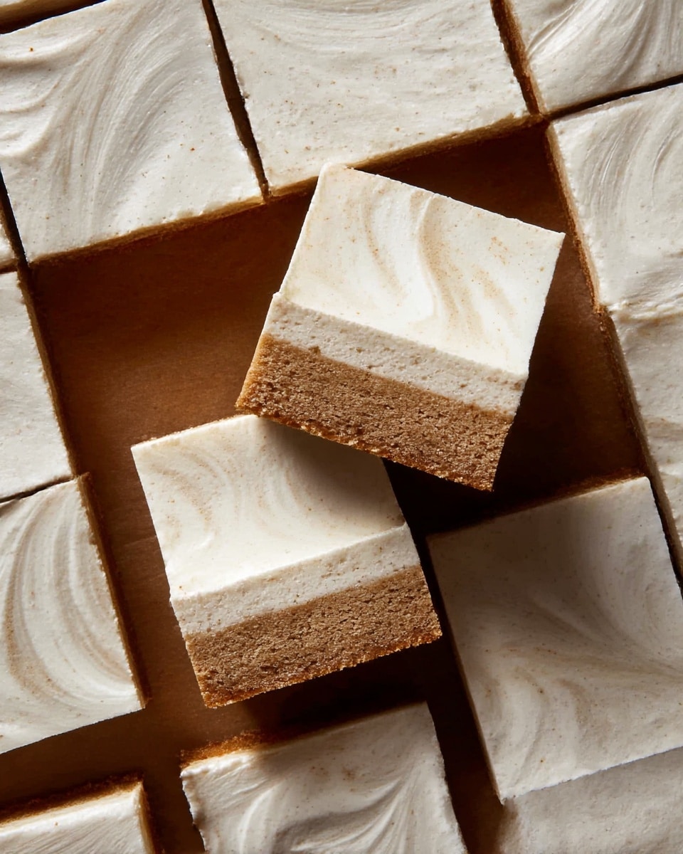Several square pieces of cake are placed on a white marbled surface. Each cake piece has two layers: a bottom layer that is a thick, moist, light brown cake and a top layer that is a smooth, creamy, off-white frosting spread evenly with gentle swirls. Two pieces are slightly lifted and overlapping in the center, showing the thickness of each layer clearly. Photo taken with an iphone --ar 4:5 --v 7